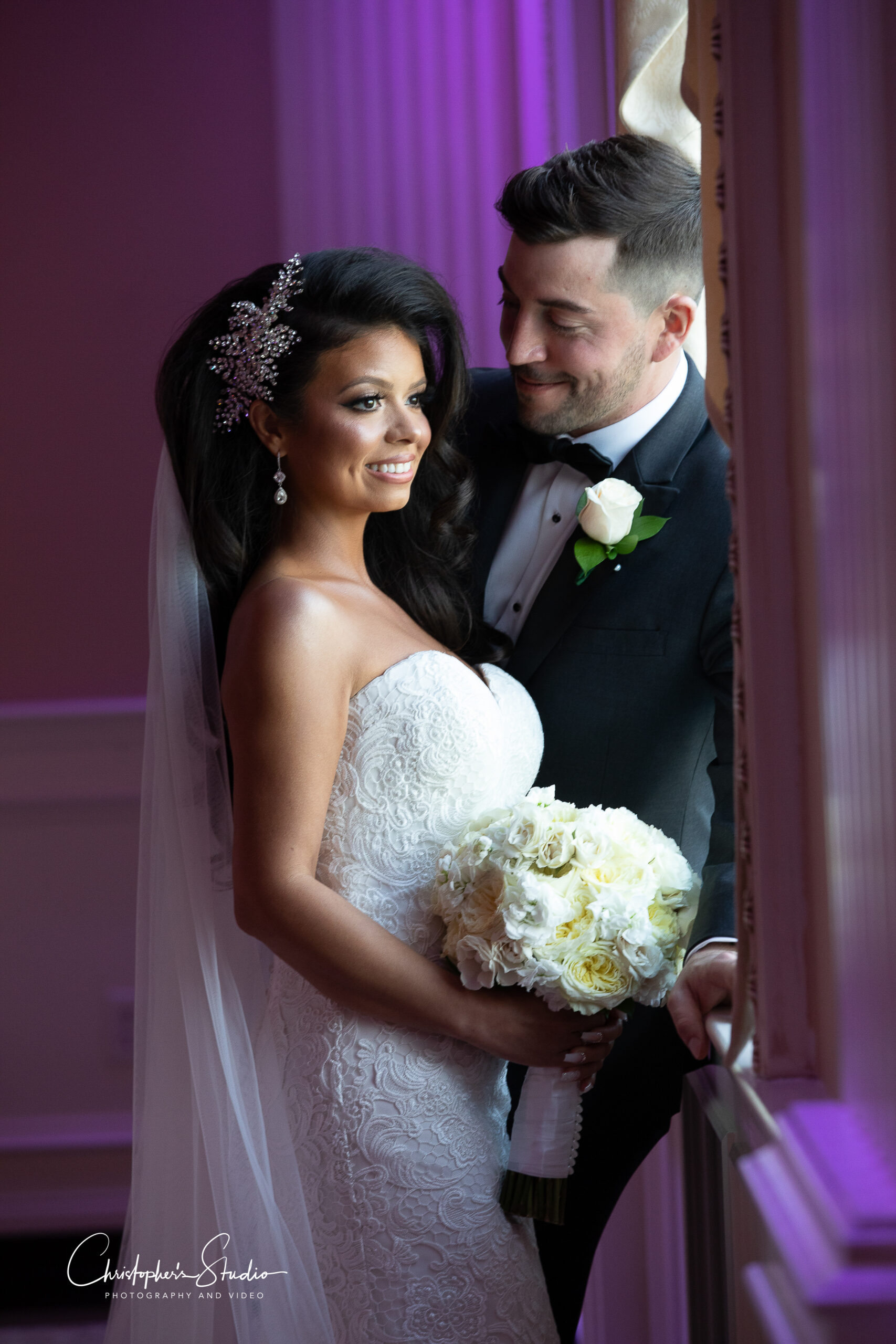 Bride and Groom at window of ballroom after wedding ceremony.