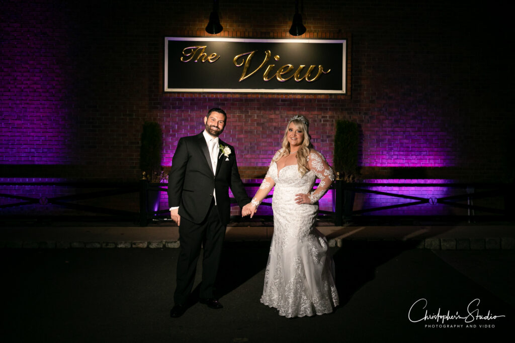 Newlyweds posing for photos in front of The View sign.