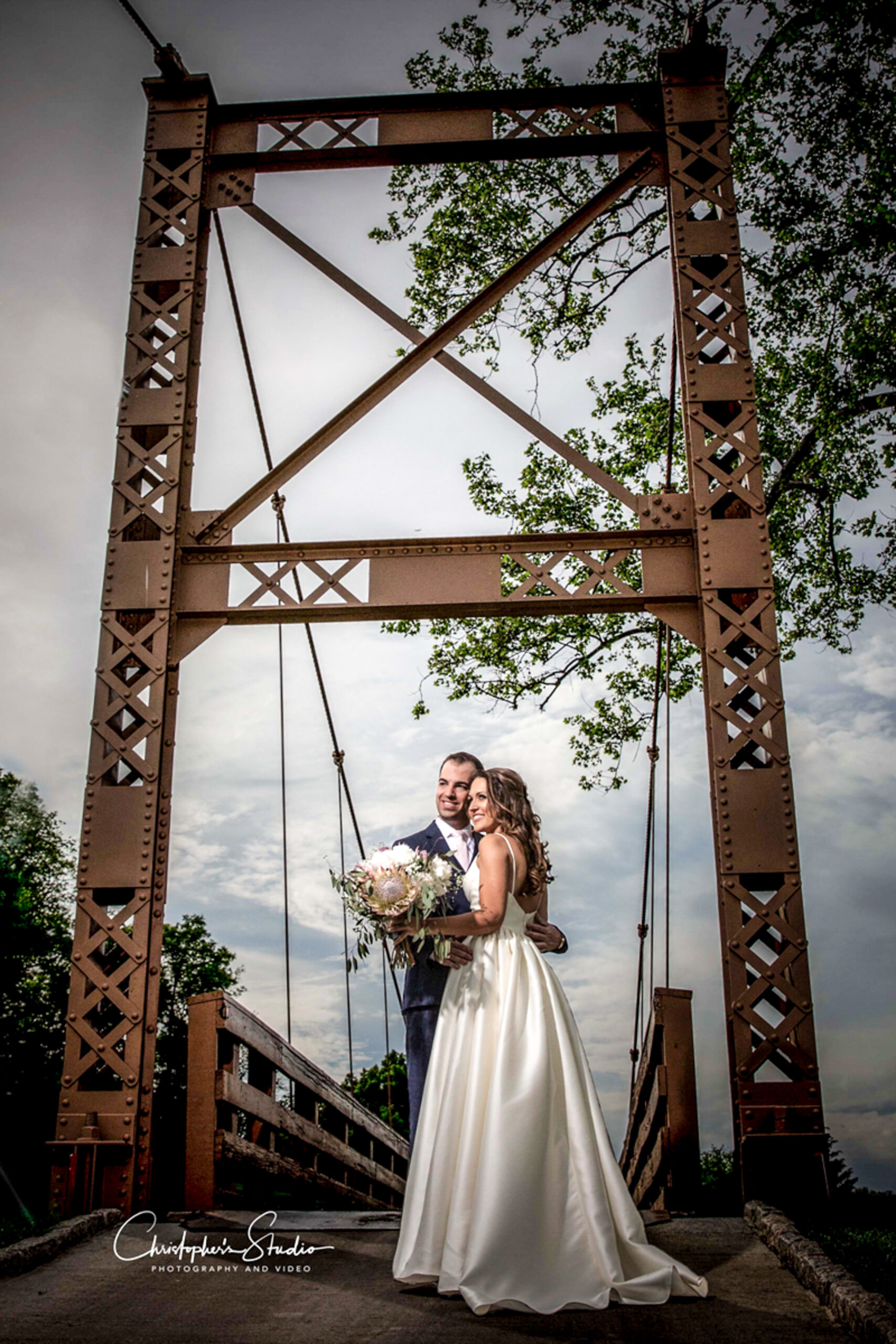 Newlyweds on country club wedding venue bridge for photo session.