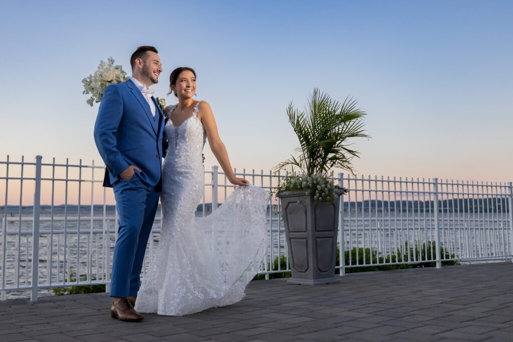 Bride and groom posing for photos in front over Hudson River.