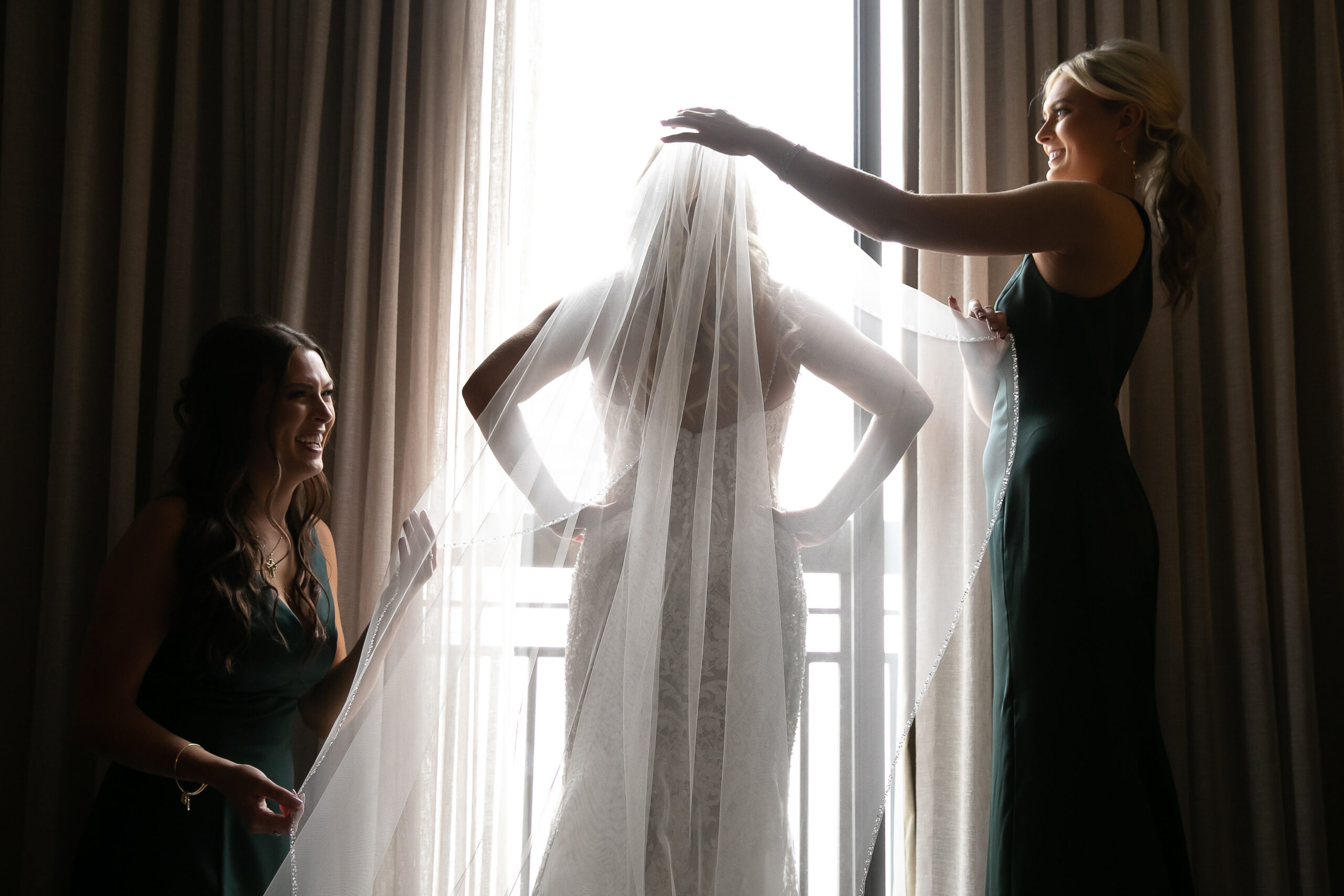 Bride and brides maids helping her get dressed. 