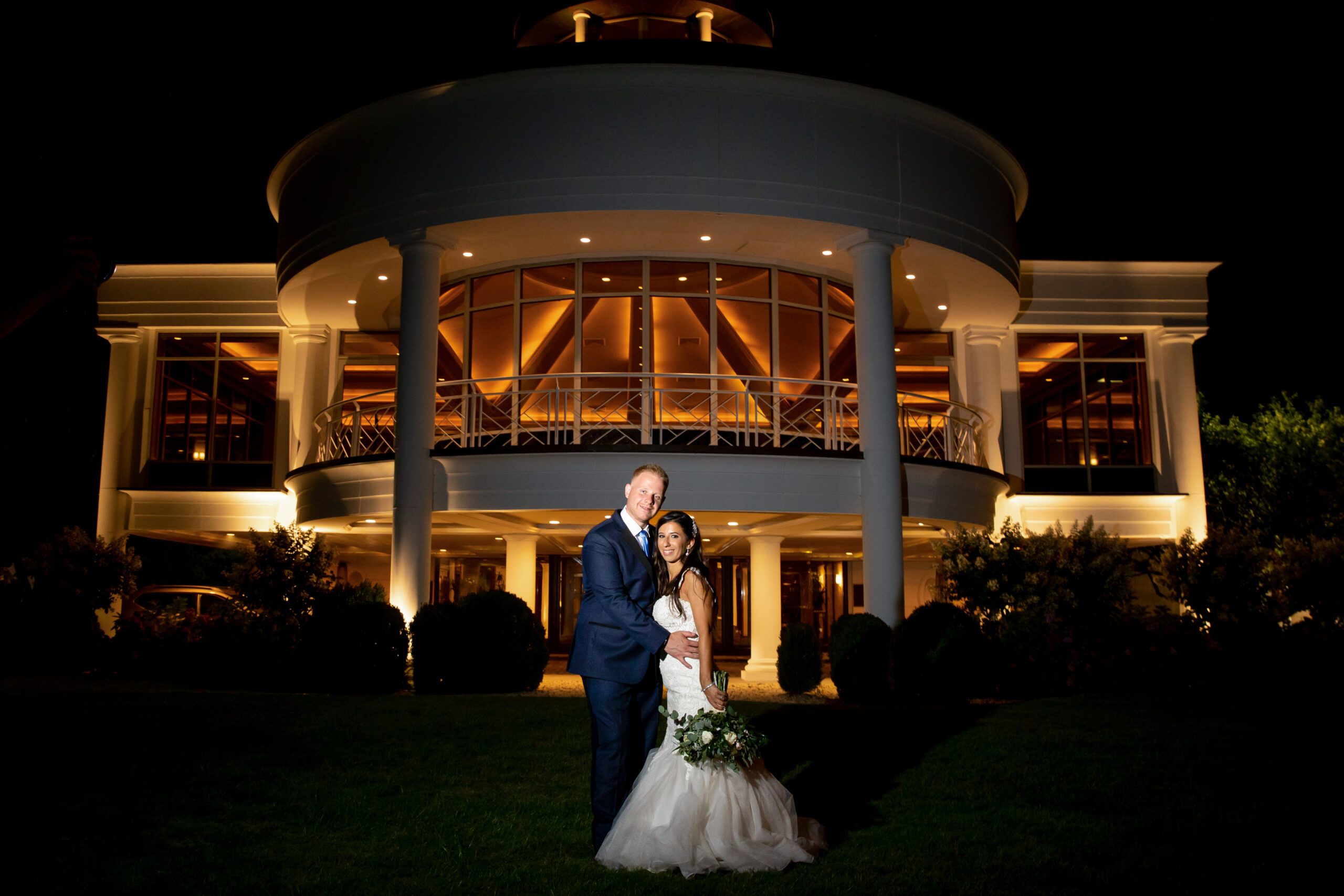 Bride and groom posing in front of the wedding venue.